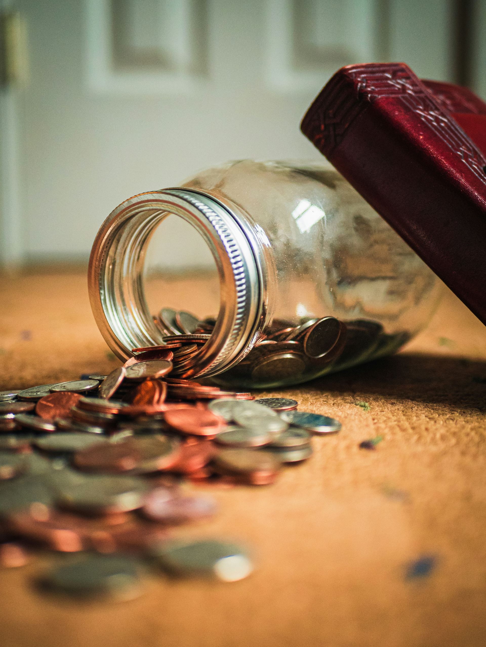 a jar of coins spillped out onto a table