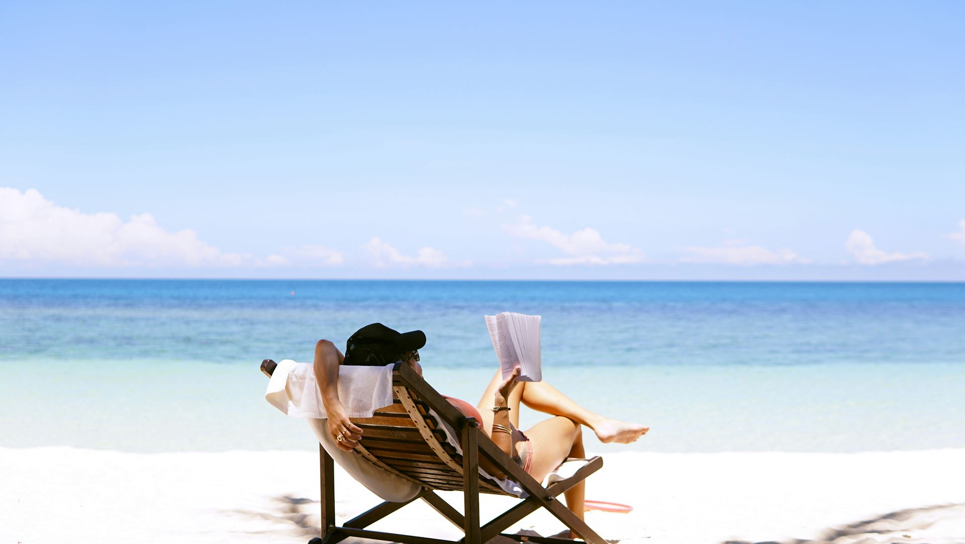 a man sat in a deck chair on the beach