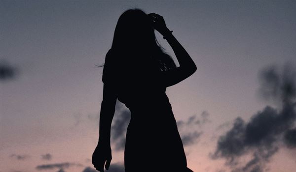 a silhouette of a woman at twilight