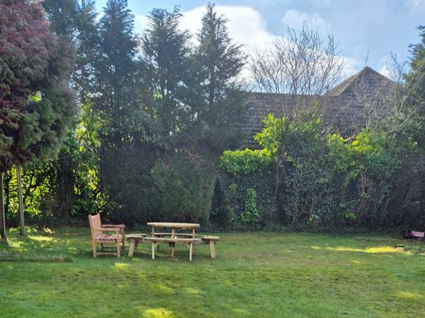 The garden area behind the Bungalow at Lake Road Surgery. There is a garden bench and picnic table installed.